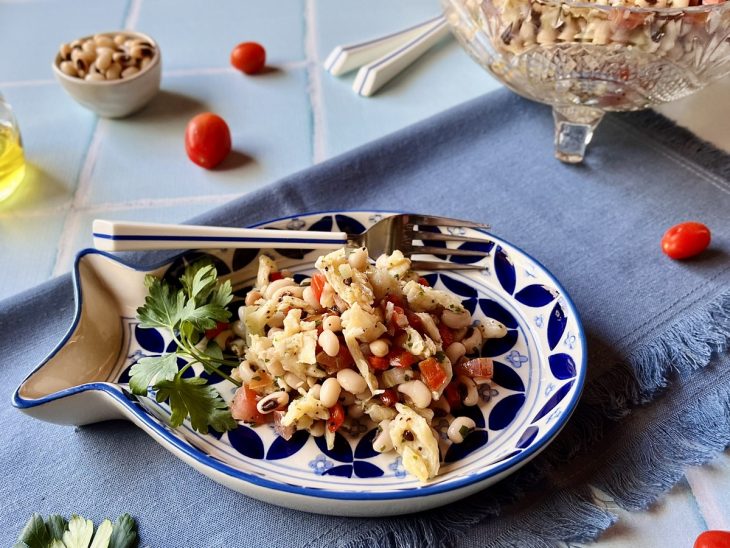 Feijão-fradinho com bacalhau servido em um recipiente individual.
