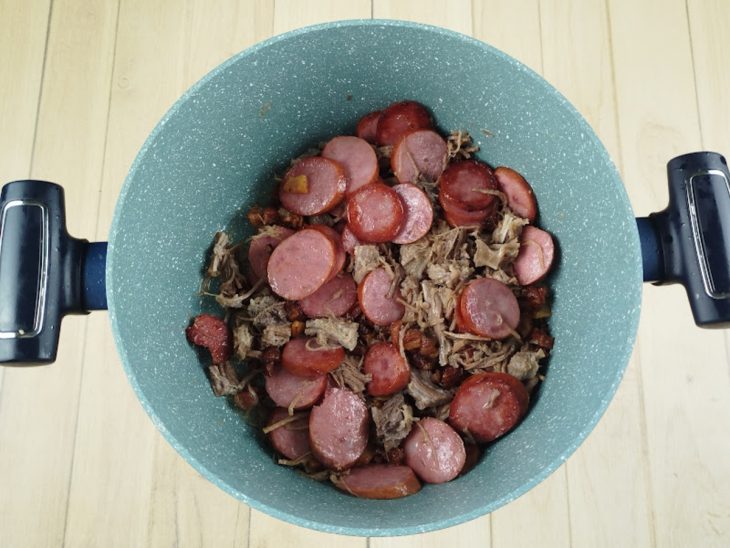 Calabresa e carne-seca adicionadas na panela.