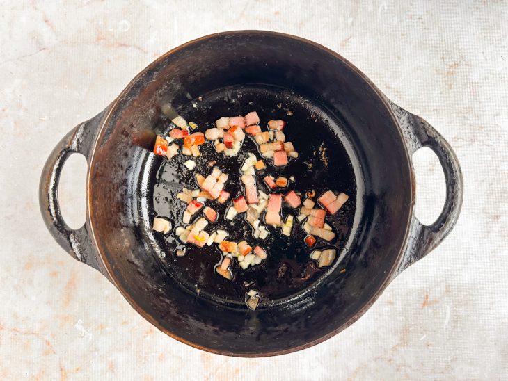 Bacon sendo frito em óleo até dourar.