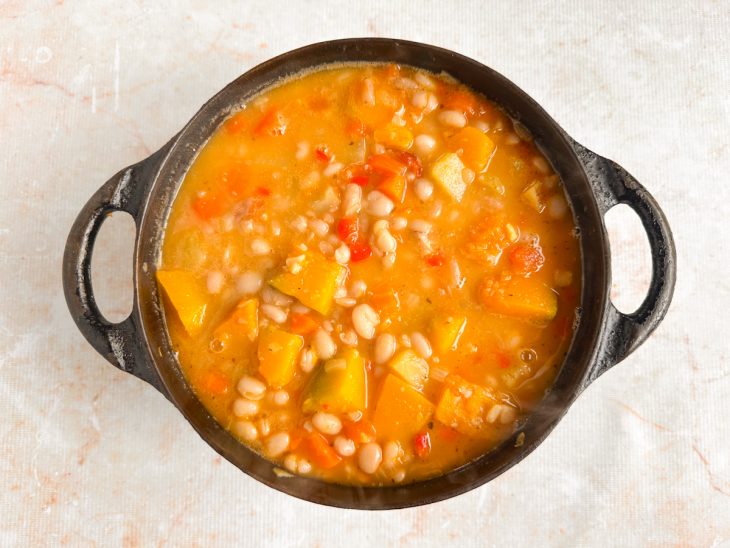 Feijão cozido sendo misturado aos legumes.