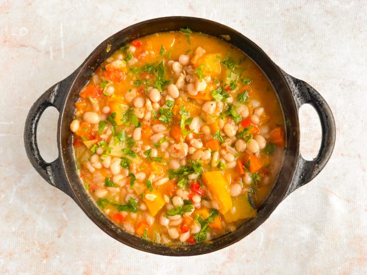 Cheiro-verde finalizando o preparo do feijão na panela.