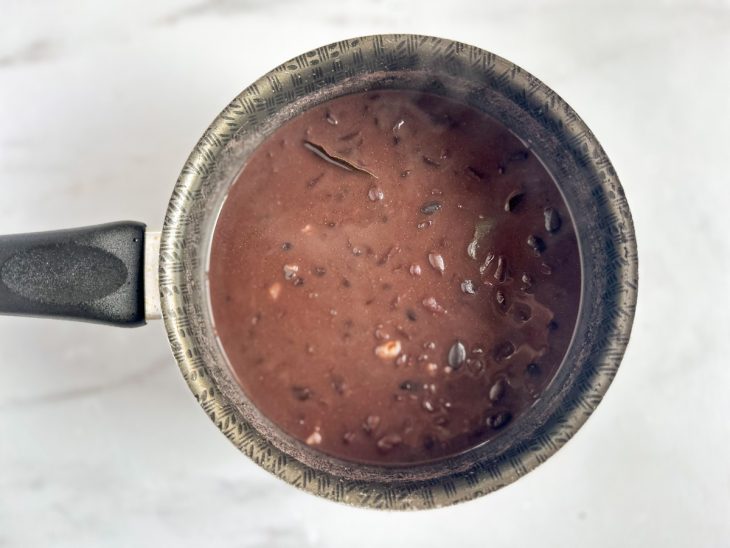 Feijão incorporado na panela com o alho.