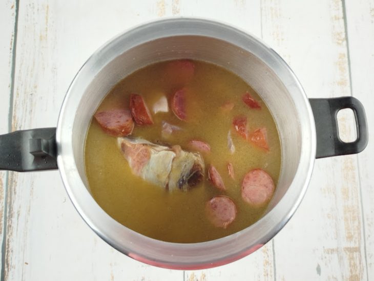 Carnes salgadas, feijão-branco e água adicionados à panela.