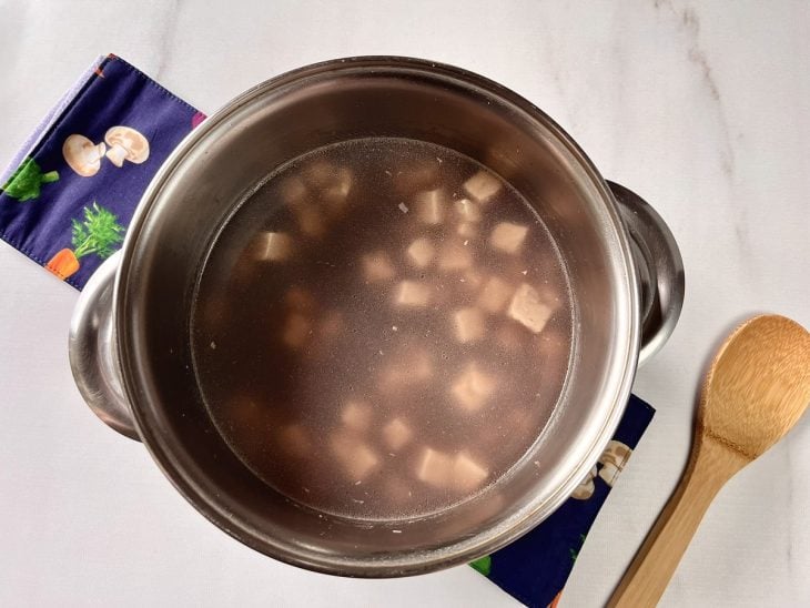 Uma panela cozinhando feijão-preto com tofu.