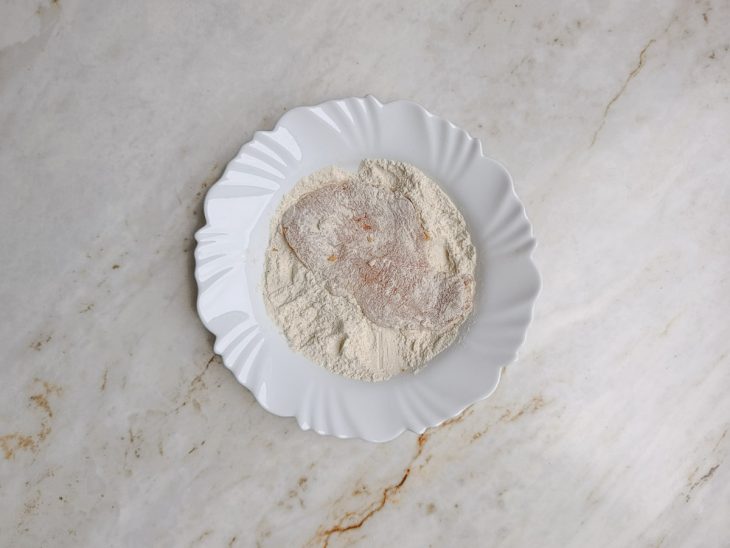 Filé sendo empanado na farinha de trigo.