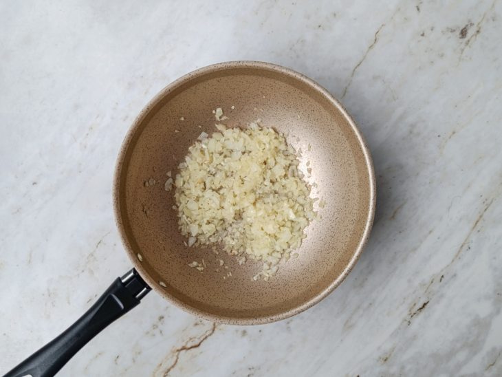 Cebola e alho refogados na panela.