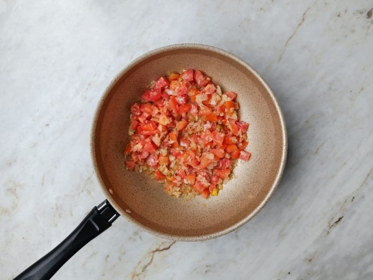 Tomate, sal e pimenta-do-reino adicionados a panela.