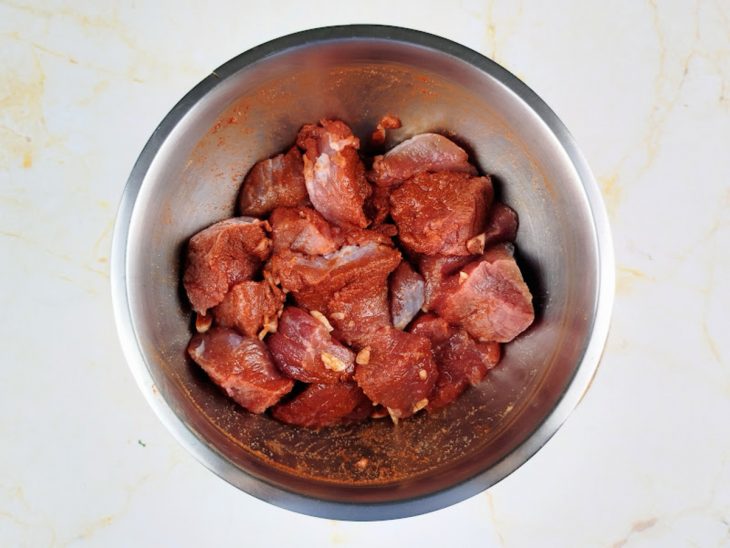 Pedaços da carne sendo temperados.