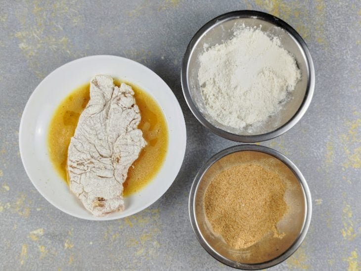 Filé de frango empanado na farinha de trigo e colocado no ovo batido.