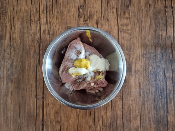 Um bowl com filés de frango sendo temperados.