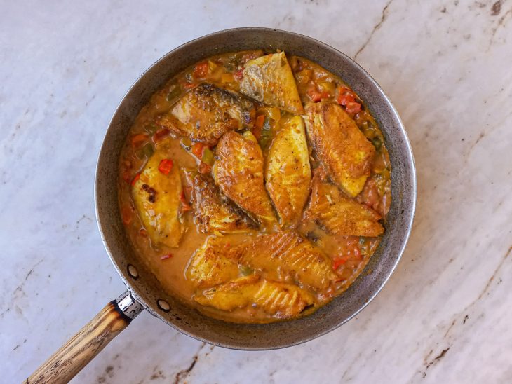 Peixes colocados na frigideira sobre o molho.