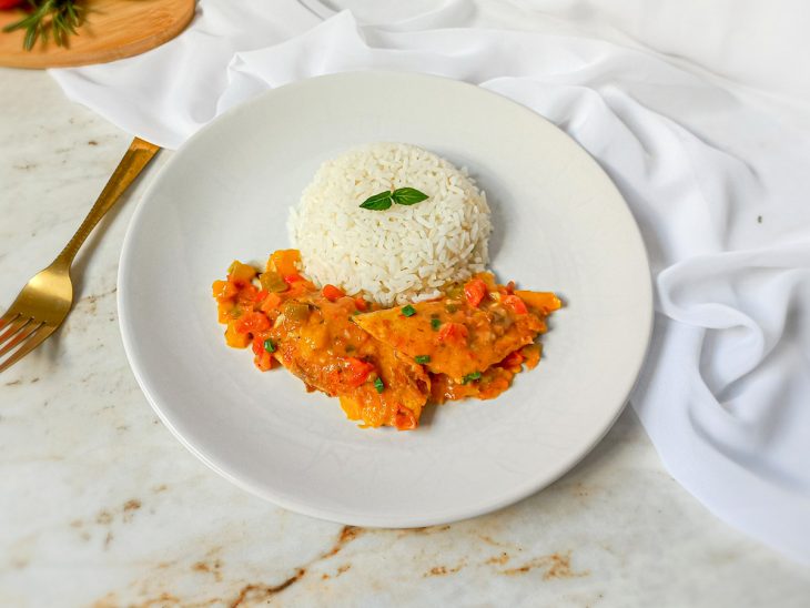 Filé de tilápia ao molho servido com arroz branco.