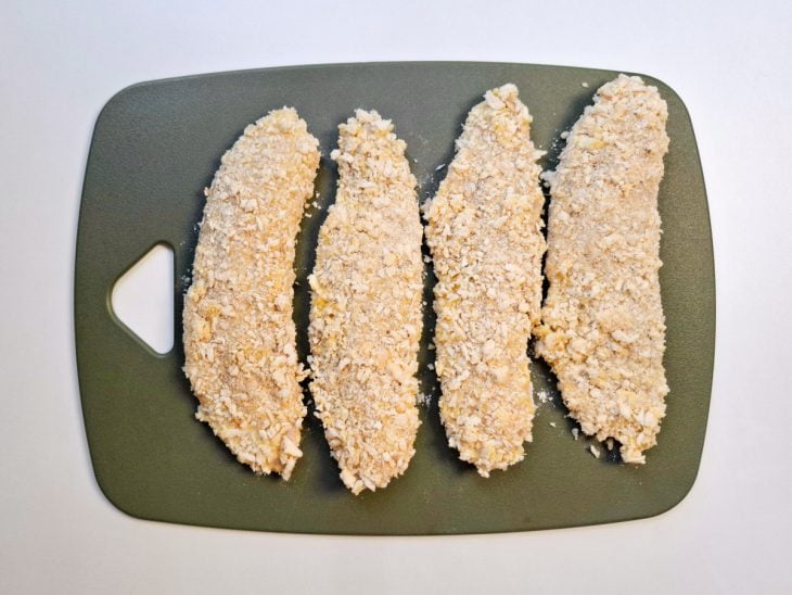 Uma tábua com os filés empanados com a farinha panko.