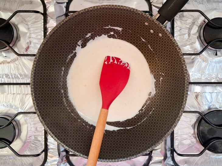 Creme de leite, sal, pimenta-do-reino e suco de limão adicionados a frigideira.