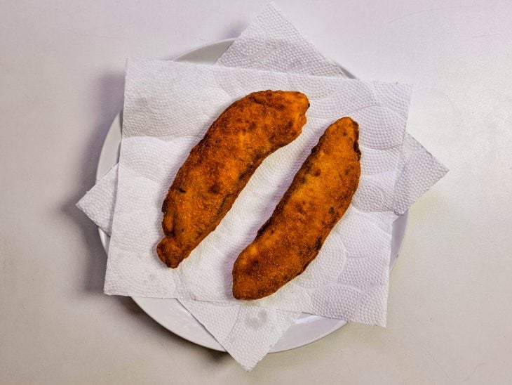 filés de tilápia escorrendo em papel toalha depois de serem fritos.
