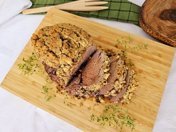 Filé mignon com crosta de castanhas com filés cortados em uma tábua.