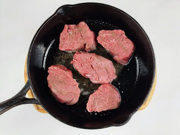 medalhões de carne selados em panela de ferro.