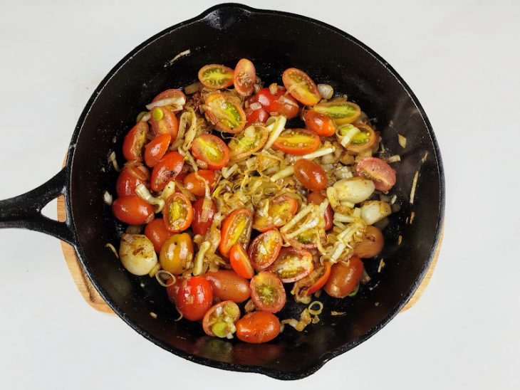 tomate adicionado ao refogado de alho-poró.