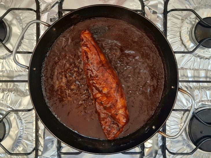 Panela com o molho e a carne ao fogo.