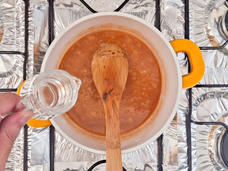 Água adicionada na panela com açúcar derretido.