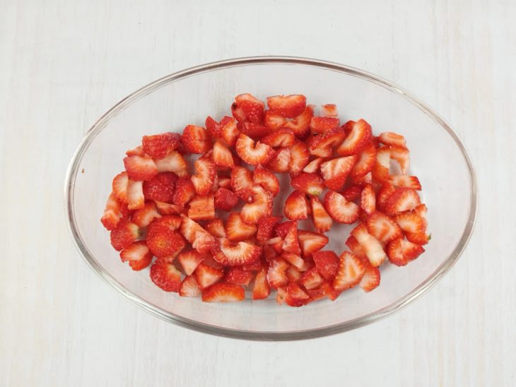 Camada de morangos picados colocada no refratário.