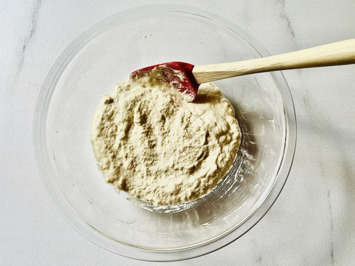 Tigela de vidro com farinha e a mistura de água morna.