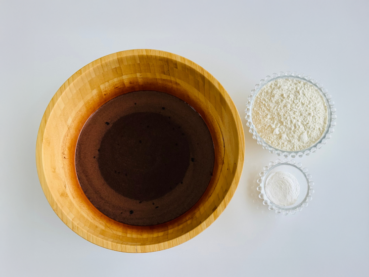 Farinha de trigo e fermento sendo misturados delicadamente à massa.