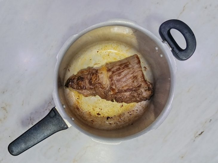 Fraldinha sendo selada na panela de pressão com óleo.