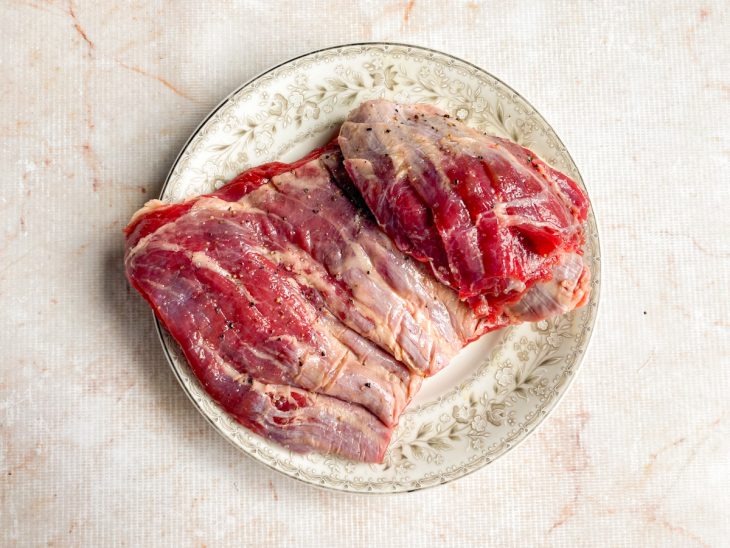 Peça da fraldinha num prato, temperada.