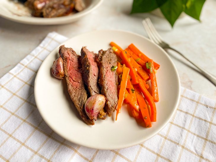 Num prato, as tiras da fraldinha servidas com cenouras cortadas em palitos.