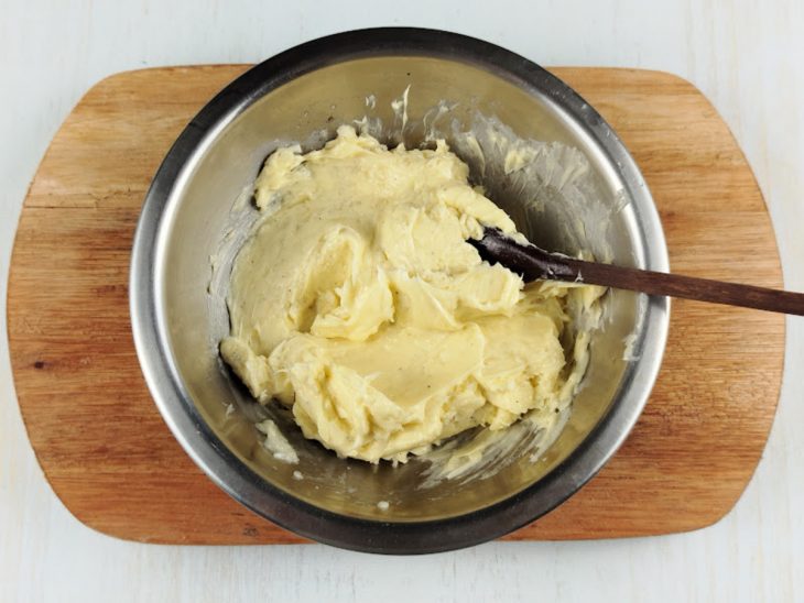 Manteiga, alho, sal e pimenta-do-reino misturados em uma tigela.