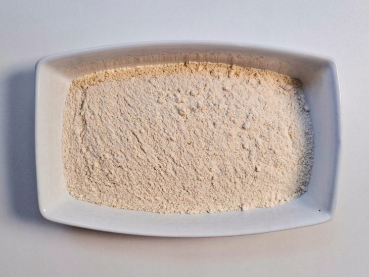 Farinha de trigo e farinha de rosca misturadas em um recipiente.