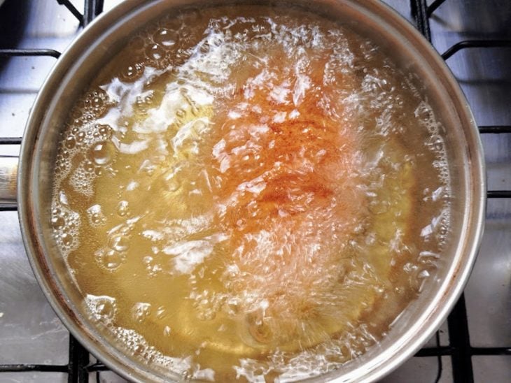 Panela com óleo e o frango a fritar.