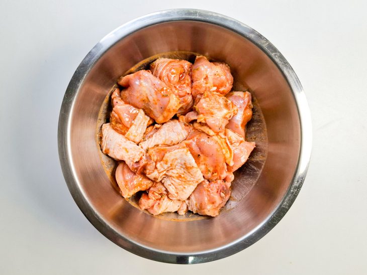 Pedaços de frango temperados em uma tigela.