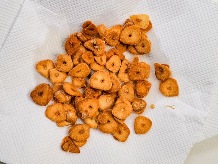 Alhos fritos sobre um papel toalha.