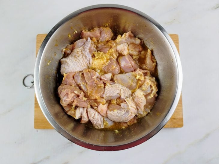 Carne com temperos numa tigela de inox.