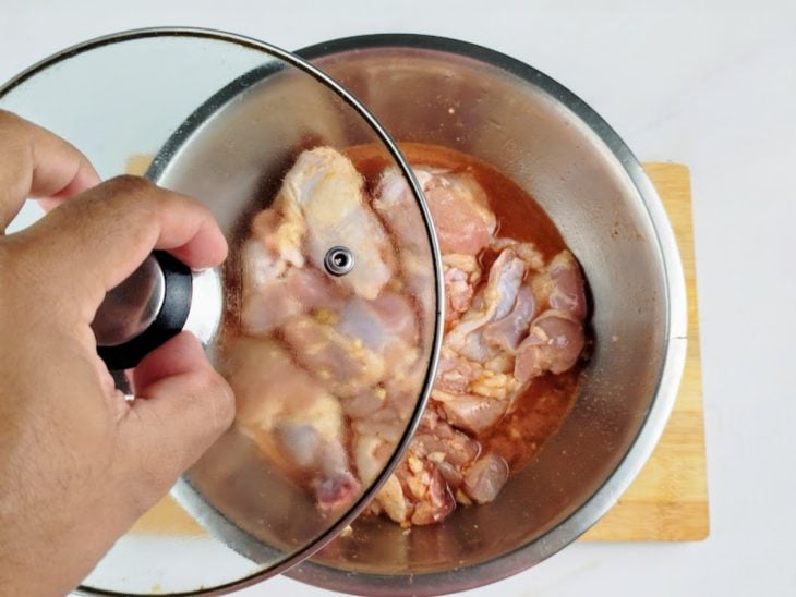 Tigela tampada com frango e temperos.