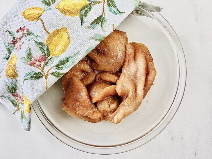Frango coberto com um pano na tigela.