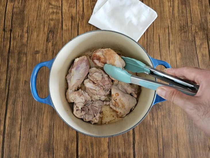 Panela com alguns pedaços de frango sendo selados até dourar.