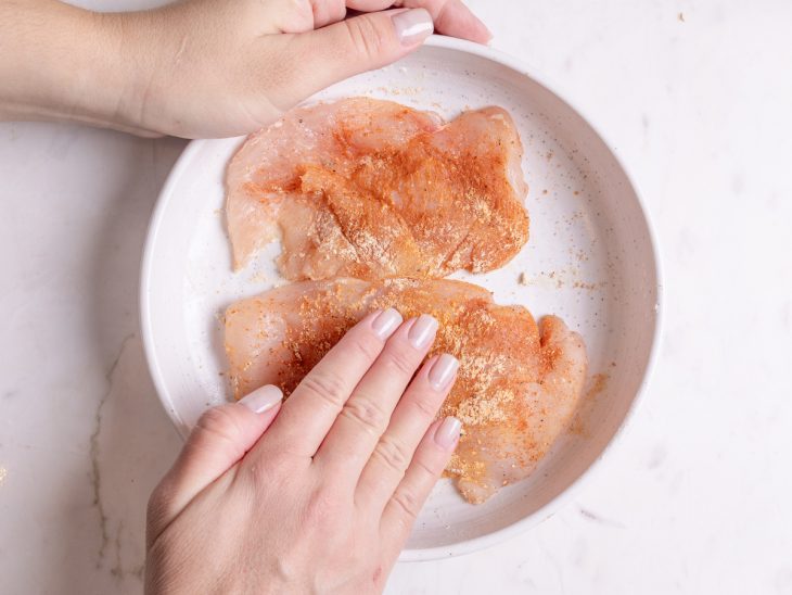 Temperos secos espalhados sobre os filés de frango.