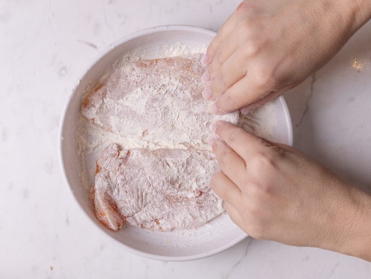 Farinha de trigo espalhada sobre os filés de frango.