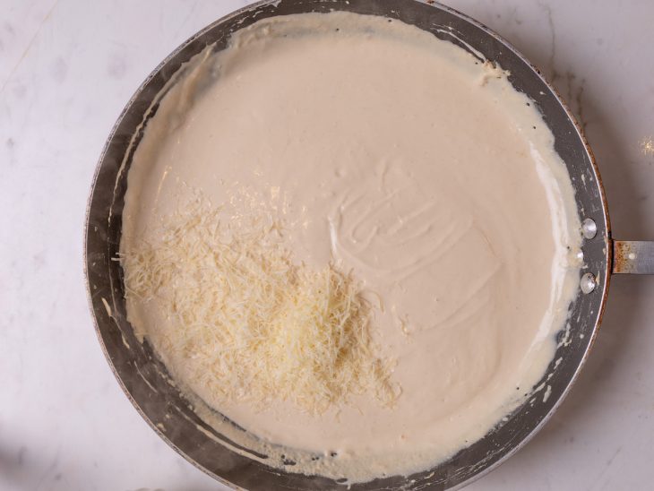 Queijo ralado adicionado a frigideira.