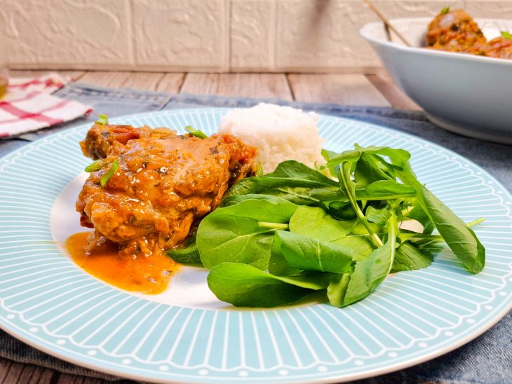 frango ao molho servido com arroz e salada.