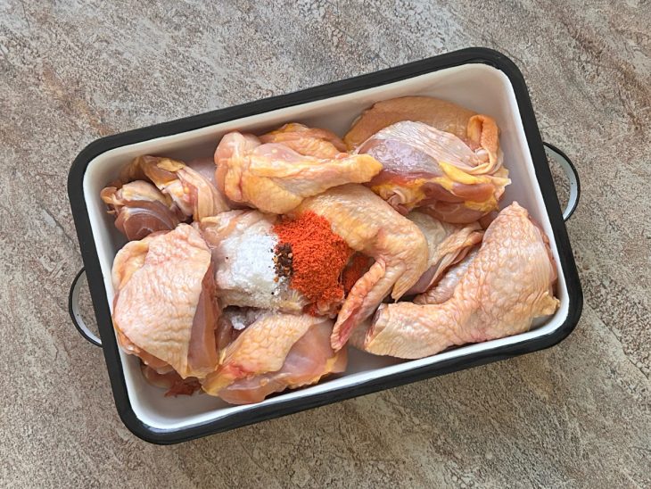 Temperos adicionados sobre os pedaços de frango.