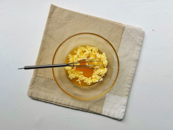 Recipiente com alguns ingredientes com coloração amarela - uma parte líquida, outra mais sólida.