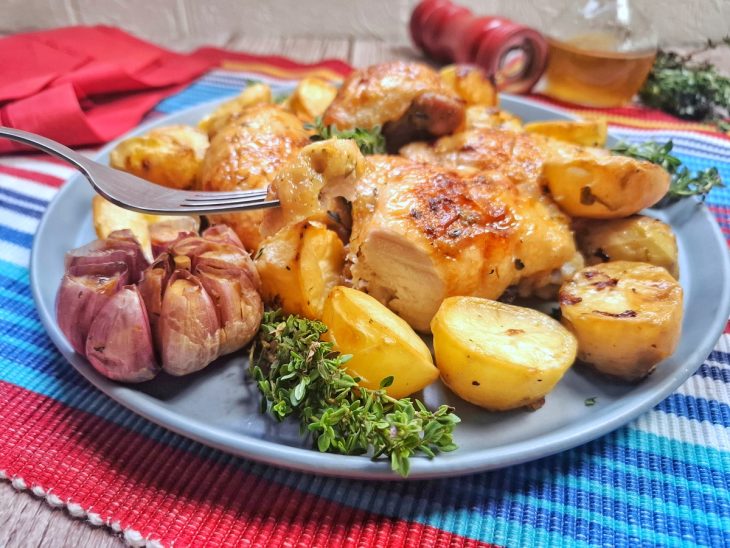 Um prato com frango assado com batatas.