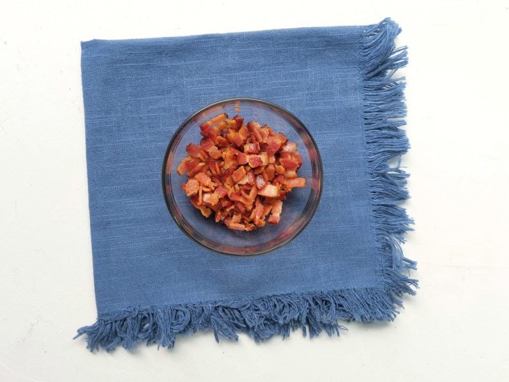 Um recipiente com bacon frito em cubinhos.