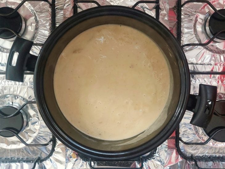 Uma panela com frango e creme de batata.