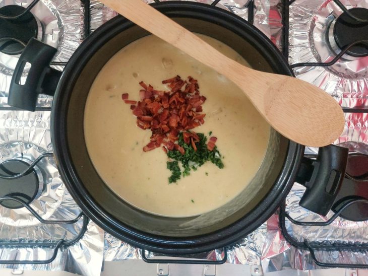 Uma panela com creme de batata com a adição de bacon e cheiro-verde.