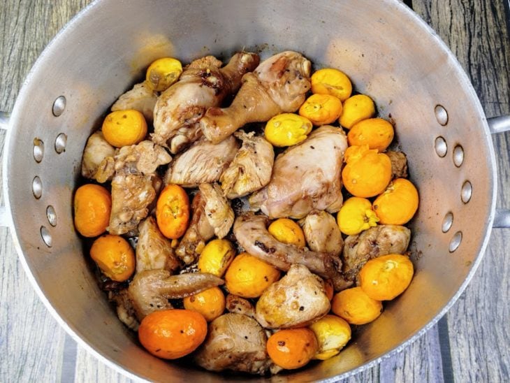 Frango e pequi em uma panela.